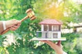 Property auction, Woman hand holding gavel wooden and model house on wtite background, lawyer of home real estate and ownership Royalty Free Stock Photo