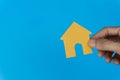 Property concept. Home loan, reverse mortgage, housing, business and finance. A man hand holding small house on blue background