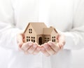 Property insurance. Cardboard house miniature in hands