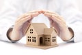 Property insurance. House miniature covered by hands. Royalty Free Stock Photo