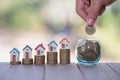 Property investment and house mortgage financial concept, Hand putting money coin stack with model house Royalty Free Stock Photo