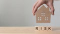 Property investment and house mortgage financial. Risk management concept. Hand putting wooden home on wood block Royalty Free Stock Photo