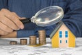 Property Tax on buildings - Property Real Estate concept with a small home model, euro coins group and magnifying glass Royalty Free Stock Photo