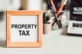 PROPERTY TAX text in wooden frame. Financial Concept