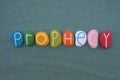 Prophecy word composed with multi colored stone letters over green sand