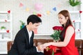 Proposal of marriage with engagement diamond ring and give red rose flower bouquet while Asian couple lover commitment for living Royalty Free Stock Photo