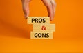 Pros and cons symbol. Wooden blocks with words `Pros and cons`. Beautiful orange background, businessman hand. Business, pros an Royalty Free Stock Photo