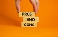 Pros and cons symbol. Wooden blocks with words `Pros and cons`. Beautiful orange background, businessman hand. Business, pros an Royalty Free Stock Photo