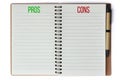 Pros and cons text words written on notepad with pen on the side and empty pages for text isolated on a seamless white background.