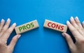 Pros vs Cons symbol. Concept word Pros vs Cons on wooden blocks. Businessman hand. Beautiful blue background. Business and Pros vs Royalty Free Stock Photo