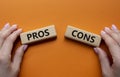 Pros vs Cons symbol. Concept word Pros vs Cons on wooden blocks. Businessman hand. Beautiful orange background. Business and Pros Royalty Free Stock Photo