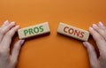 Pros vs Cons symbol. Concept word Pros vs Cons on wooden blocks. Businessman hand. Beautiful orange background. Business and Pros Royalty Free Stock Photo