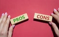 Pros vs Cons symbol. Concept word Pros vs Cons on wooden blocks. Businessman hand. Beautiful red background. Business and Pros vs Royalty Free Stock Photo