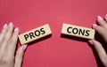 Pros vs Cons symbol. Concept word Pros vs Cons on wooden blocks. Businessman hand. Beautiful red background. Business and Pros vs Royalty Free Stock Photo