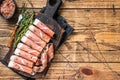 Prosciutto crudo Dry cured parma ham on a wooden cutting board with thyme. wooden background. Top View. Copy space