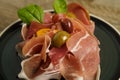 Prosciutto ham plate with olives on wooden table Royalty Free Stock Photo