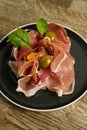 Prosciutto ham plate with olives on wooden table Royalty Free Stock Photo