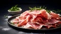 Prosciutto ham. Sliced Prosciutto with Rosemary on a dark background. Close-up of sliced of Parma ham on black plate with herbs. Royalty Free Stock Photo