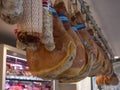 Prosciutto hams and salami displayed in a traditional butcher shop