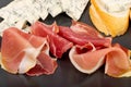 Prosciutto Tapas and Mold Cheese on Black Plate, Spanish Jamon Slices, Parma Ham, Sliced Serrano, Iberico Royalty Free Stock Photo