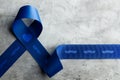 Prostate Cancer Awareness Campaign Concept. Men Healthcare. Close up of a Blue Moustache Ribbon Lying on Rough Grey Cement