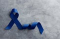 Prostate Cancer Awareness Campaign Concept. Men Healthcare. Close up of a Blue Ribbon Lying on Rough Grey Cement Concrete