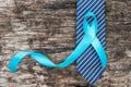 Prostate cancer awareness concept with light blue ribbon on necktie and old aged wood for men\'s health care campaign Royalty Free Stock Photo