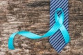 Prostate cancer awareness concept with light blue ribbon on necktie and old aged wood for men`s health care campaign in November Royalty Free Stock Photo