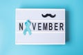 Prostate Cancer Awareness month, Light blue Ribbon with mustache on lightbox with November text background for supporting people Royalty Free Stock Photo