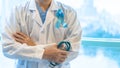 Prostate cancer blue awareness ribbon for men health in November with light blue bow color on medical doctor in clinical lab gown