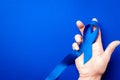 Prostate care. Awareness prostate cancer of men health in November. Blue ribbon in hands isolated on deep blue