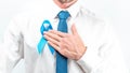 Prostate care. Awareness prostate of men health in November. Hipster men in bright shirt, cyan tie with blue ribbon in hands on
