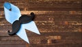 Prostatitis symbol. Mustache on a blue ribbon on a wooden background with place for text