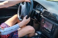 Prosthetic amputated hand of Caucasian man on the steering wheel who drives car