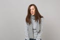 Prostrate exhausted irritated young woman in gray sweater, scarf on grey background studio portrait. Healthy