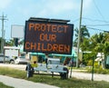 Protect our children sign on the edge of the road