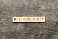 PROTECT word written on wood block. PROTECT text on cement table for your desing, concept