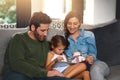 Protect your children, make sure they are cyber safe. a young family using a tablet and chilling on the sofa together at Royalty Free Stock Photo