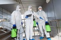 Men in protective suits deciding what to disinfect with spray