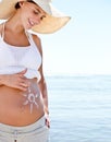 Protect your precious cargo. a beautiful pregnant woman with the sun drawn onto her belly against the background of the Royalty Free Stock Photo