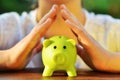 Protect your savings - with hands covering green piggy bank Royalty Free Stock Photo