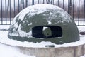 Protected military machine gun pillbox made of iron in winter in the snow.