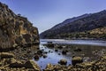 Protected natural harbour as seen behind rocks, shot low, under clear blue skies