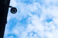 Protected surveillance camera on the background of the sky with clouds Royalty Free Stock Photo