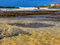 A protected tidepool with a shelf reef creating gentle waves in the background Royalty Free Stock Photo
