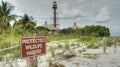 Protected Wildlife Habitat sign with lighthouse in background.