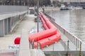 Protecting city from spring floods. Water-filled booms and sandbags on the pier of Zaryadye Park. Russia, Moscow - April