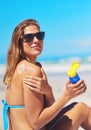 Protecting her beautiful skin. a young woman applying suntan lotion at the beach. Royalty Free Stock Photo