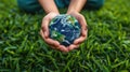 Protecting Our Planet: Hands Holding Earth on Green Grass Background for Environmental Concept Royalty Free Stock Photo