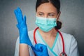 Protection against contagious disease, coronavirus. Beautiful female doctor or nurse wearing protective mask and latex or rubber Royalty Free Stock Photo